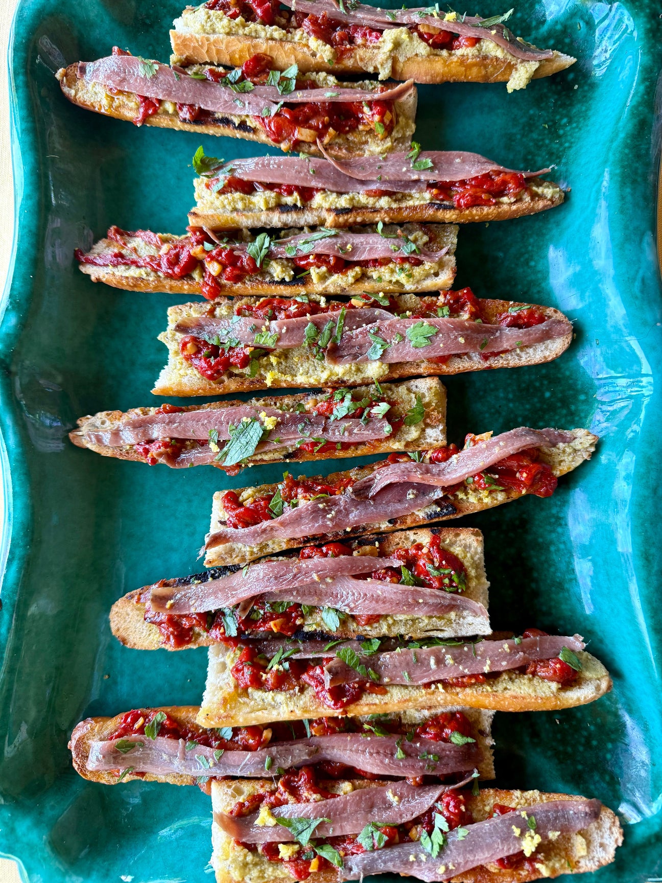 Tosta con paté de aceitunas, pimientos asados y anchoas: receta fácil con AOVE Monsieur Pegó