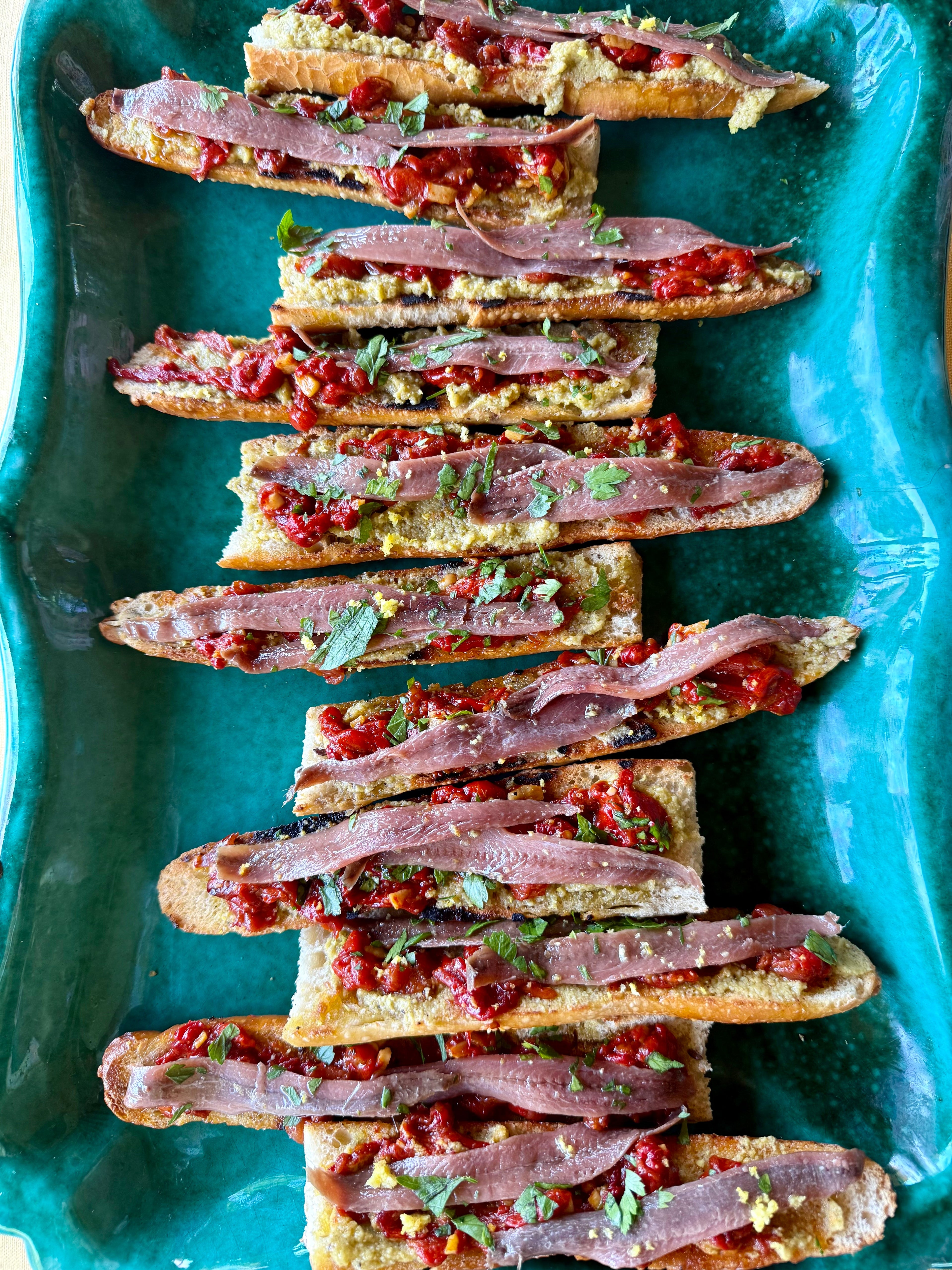 Tosta con paté de aceitunas, pimientos asados y anchoas: receta fácil con AOVE Monsieur Pegó